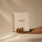 The Anchored Planner held in one hand, showing its size