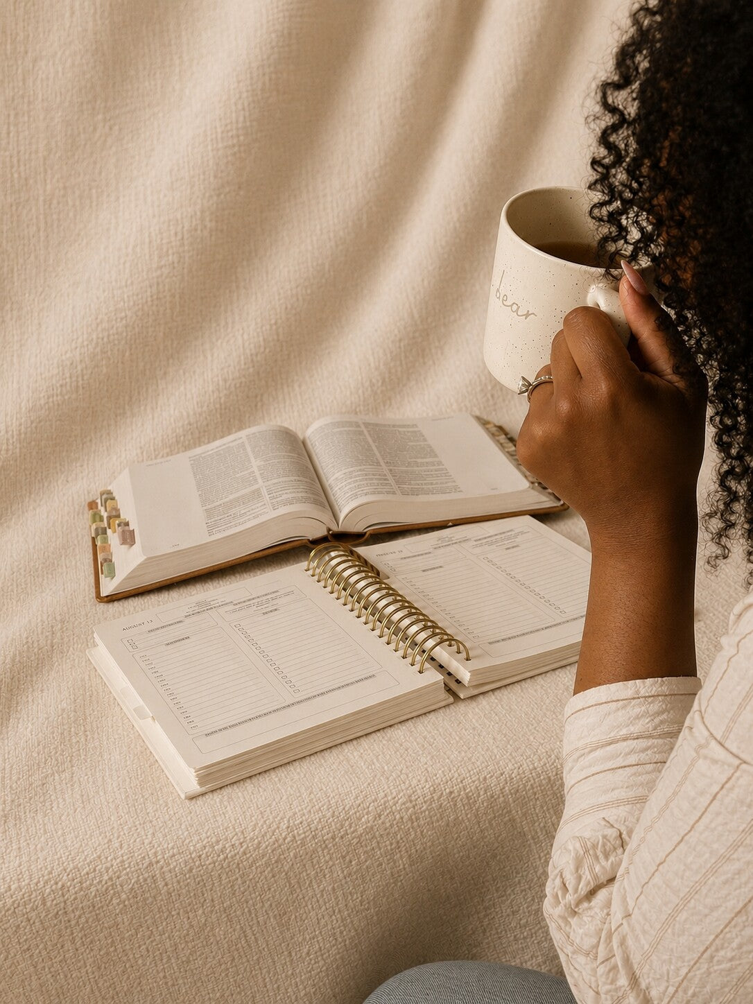 A woman with coffee, her Bible and The Anchored Planner open in front of her