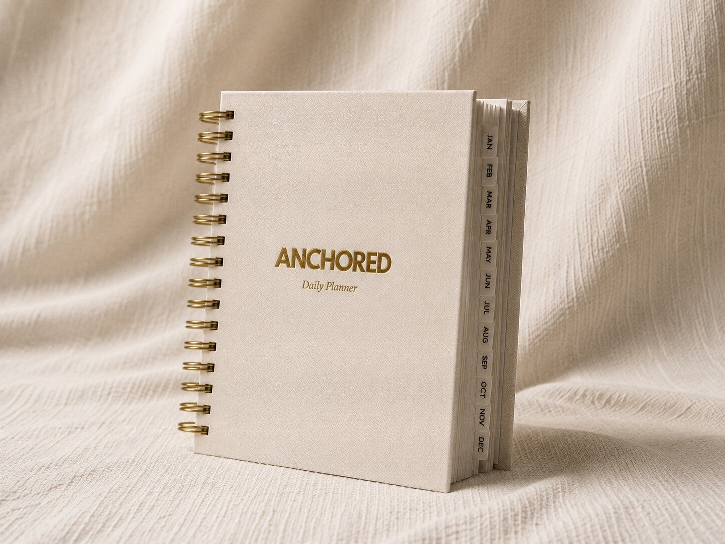 The Anchored Planner standing upright, showing the twelve monthly tabs