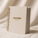 The Anchored Planner standing upright, showing the twelve monthly tabs